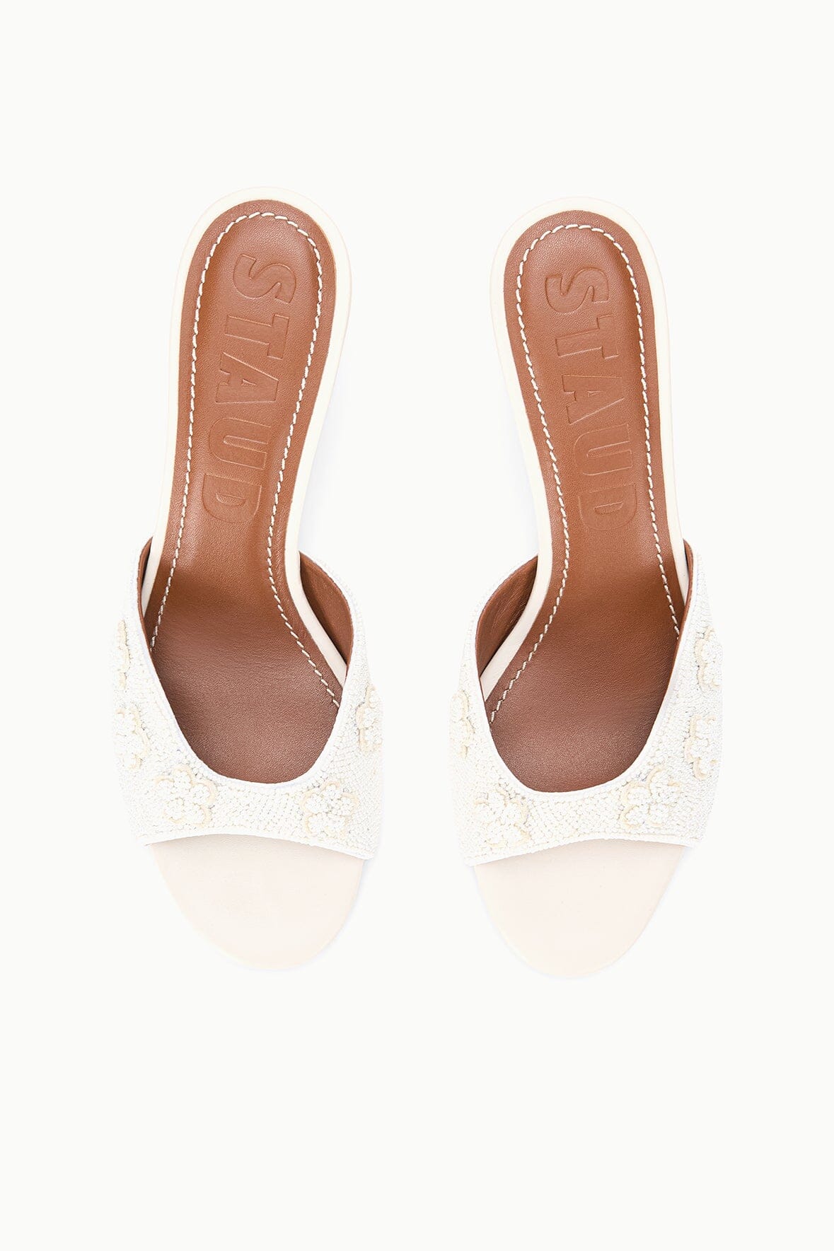 White open-toe mule sandals with textured upper and mid-height heel