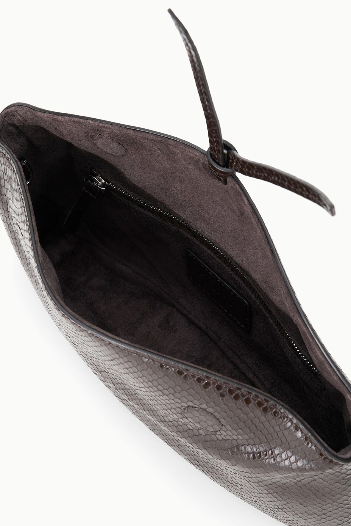 EVE clutch interior view with dark suede lining and zip pocket, snake-textured exterior