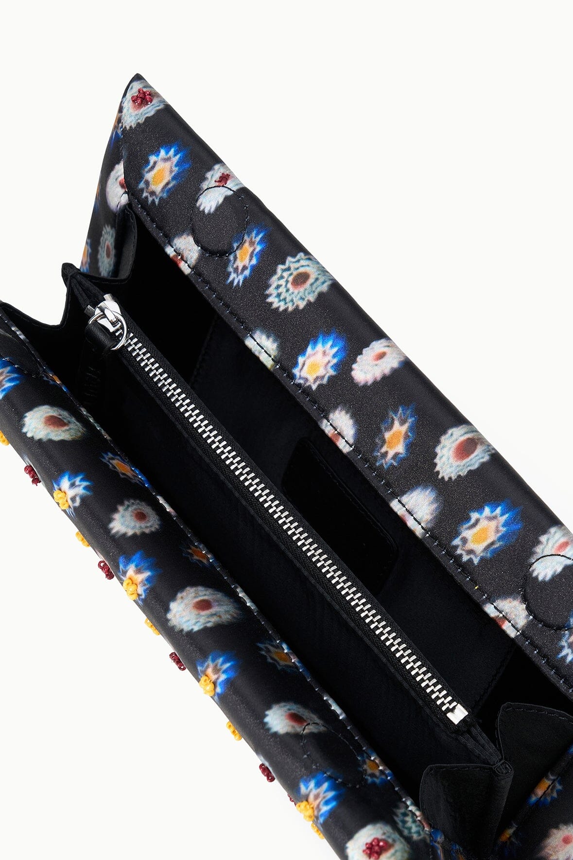 Floral-lined clutch interior with zip pocket and dark fabric opening