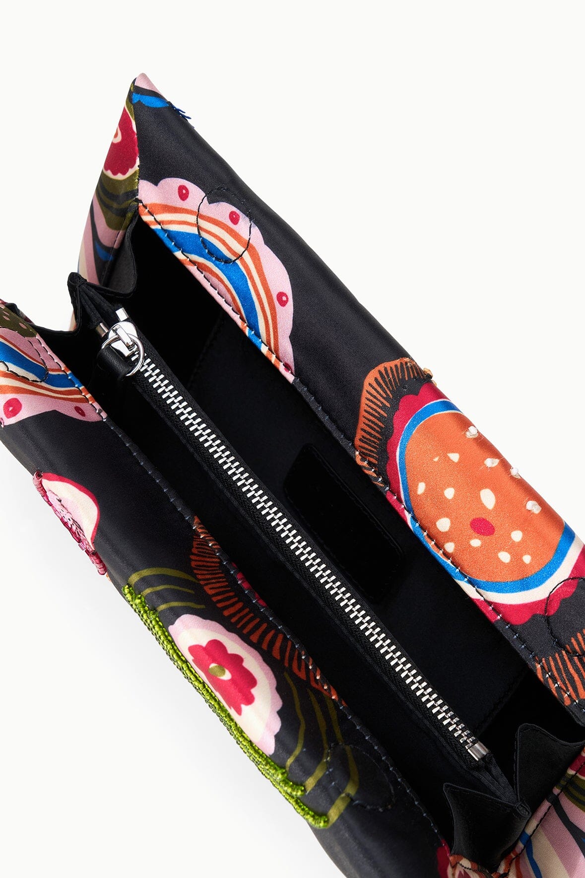 Black clutch with open zipper and vivid paisley interior fabric, Millefiore 2.0.