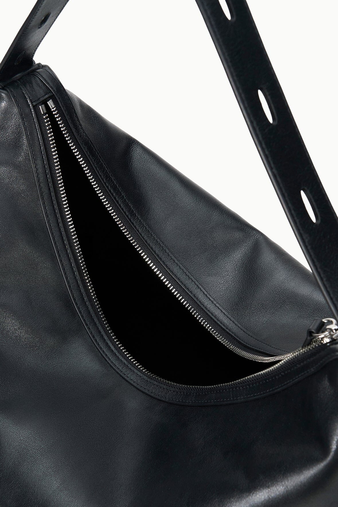 Black hobo bag close-up: double zippers at open top and textured finish