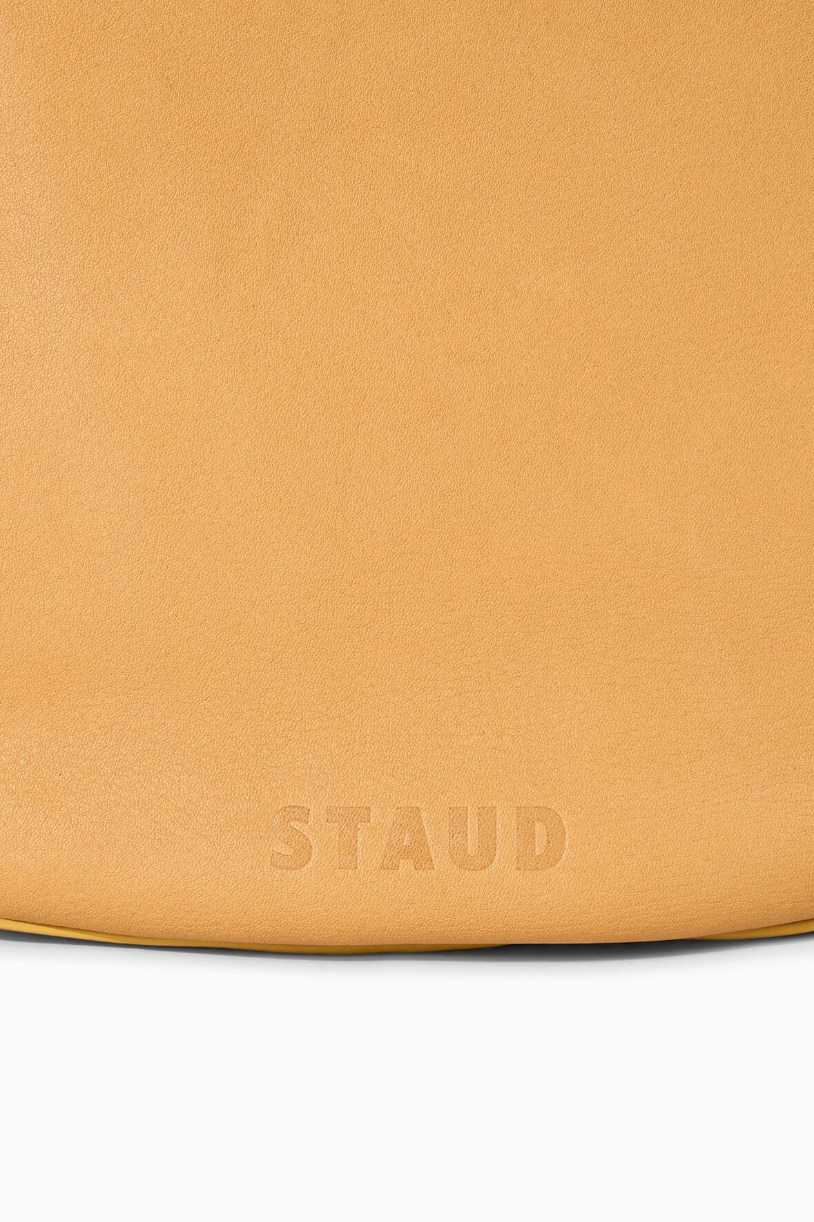 Cashew tan hobo bag with embossed "STAUD" logo at bottom edge