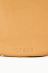 Cashew tan hobo bag with embossed "STAUD" logo at bottom edge