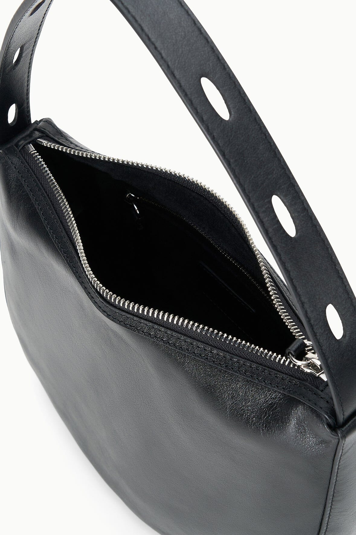 Black hobo bag showing zip pocket interior and perforated strap