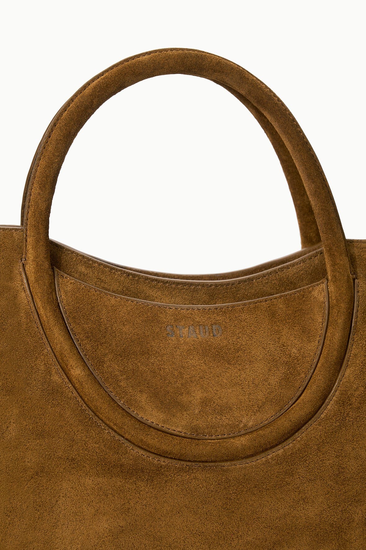 Dark tan suede satchel front with round opening and embossed MAUDE logo