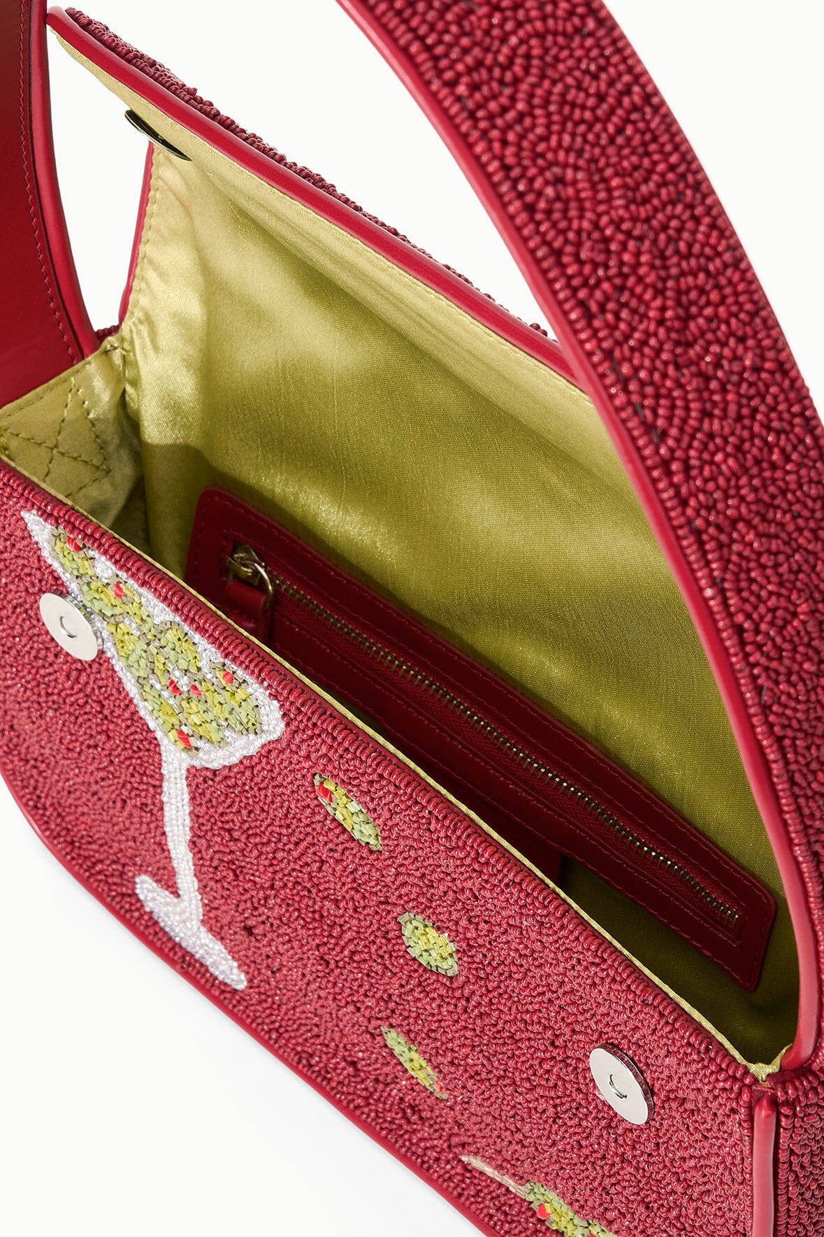 Interior view of red beaded handbag showing open top, fabric lining, and zip pocket