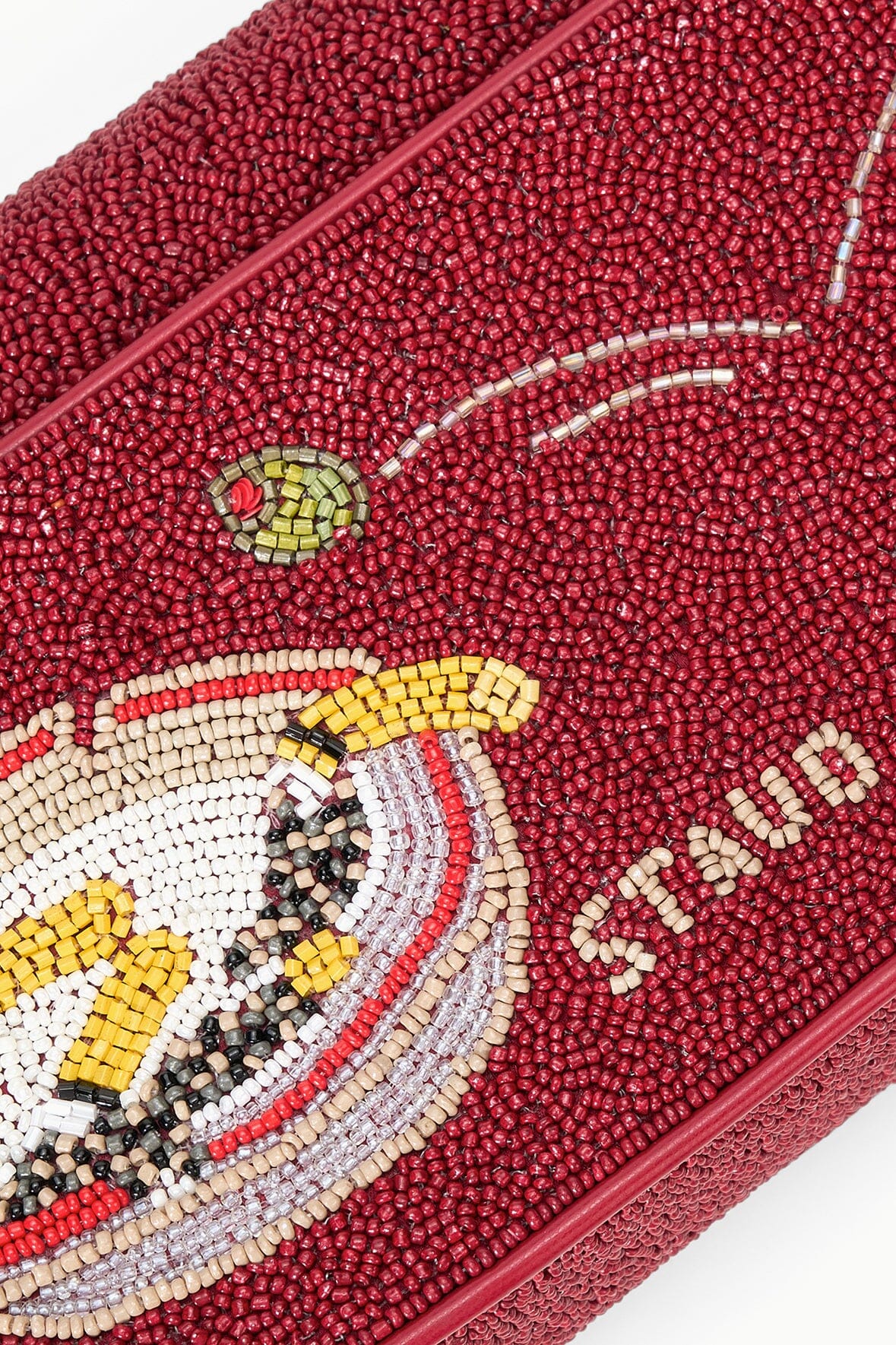 Close-up of red beaded handbag with detailed cocktail-glass beading and beaded trim