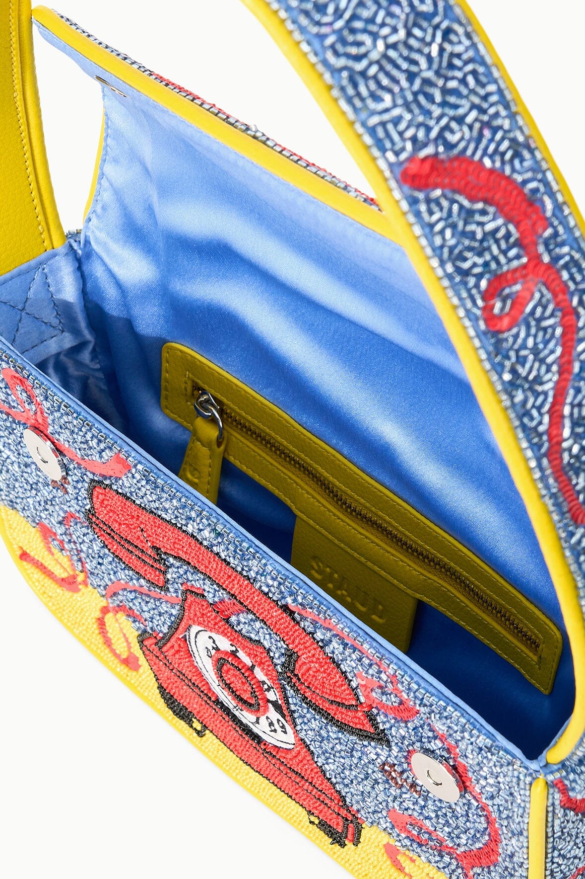 TOMMY beaded bag open detail, yellow zip top and blue interior with phone print.