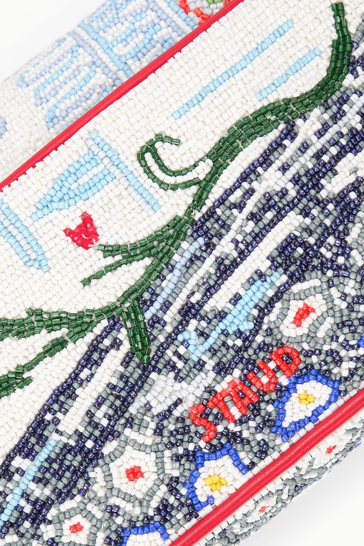 Beaded pattern close-up with green and blue details, red trim edge