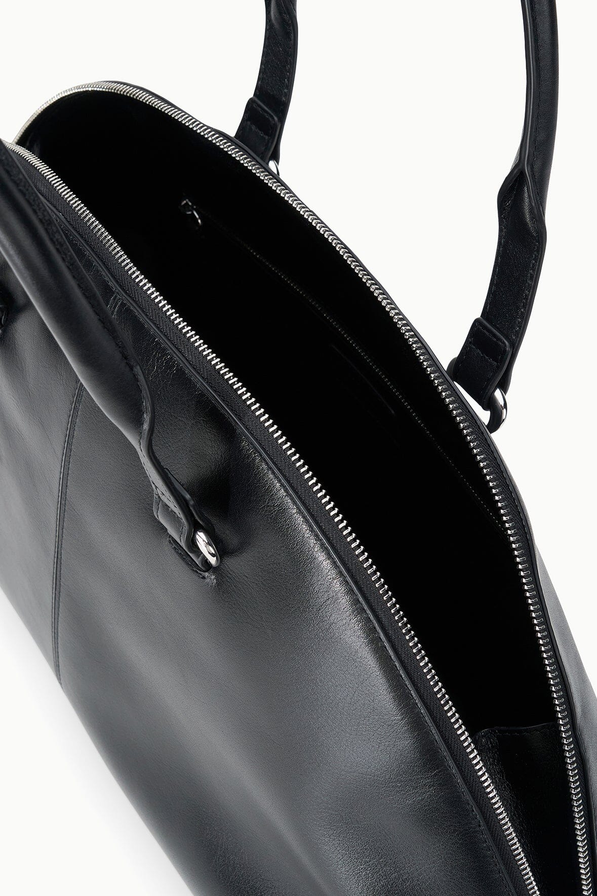 Black satchel bag interior with zip pocket, zipper track, and metal pull