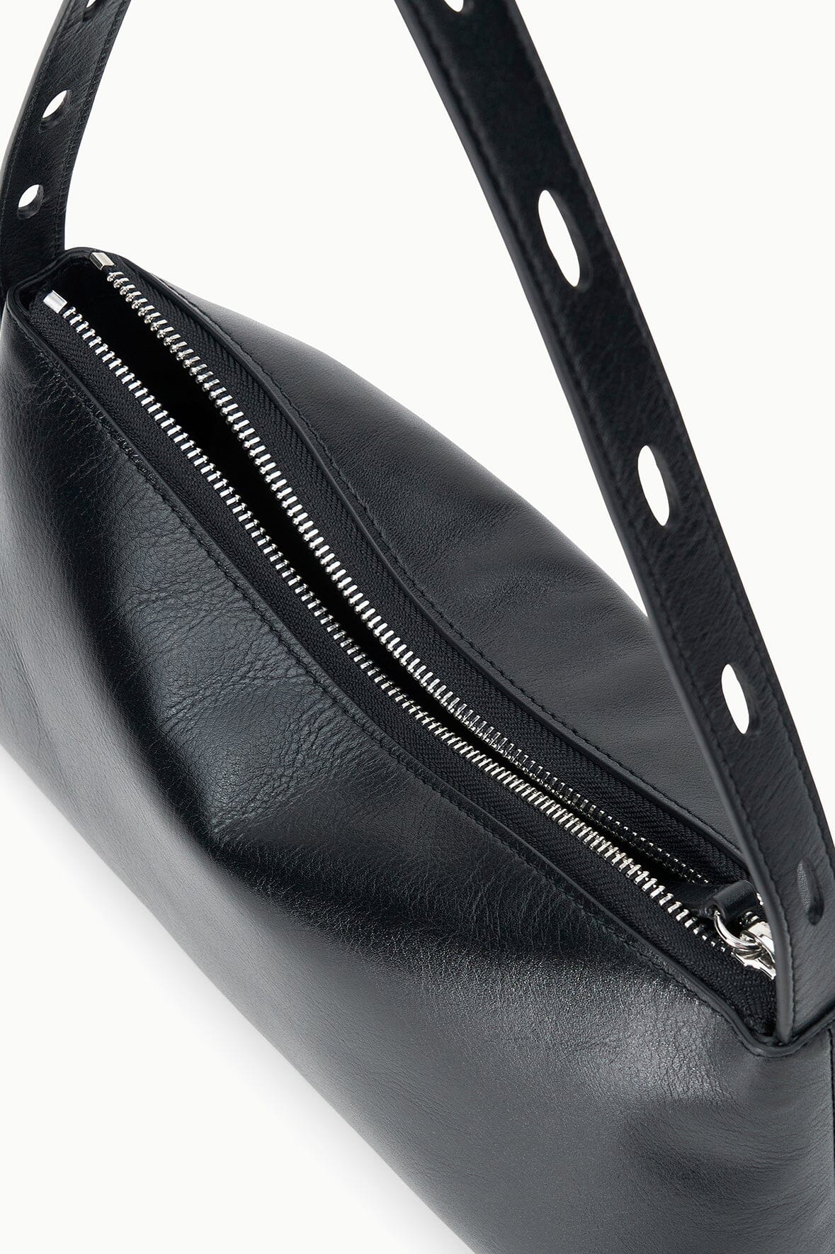 Black shoulder bag detail with front zipper and perforated strap