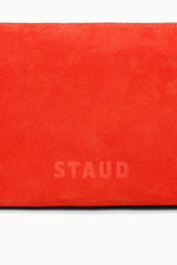 Orange suede-like shoulder bag panel with embossed “STAUD” logo