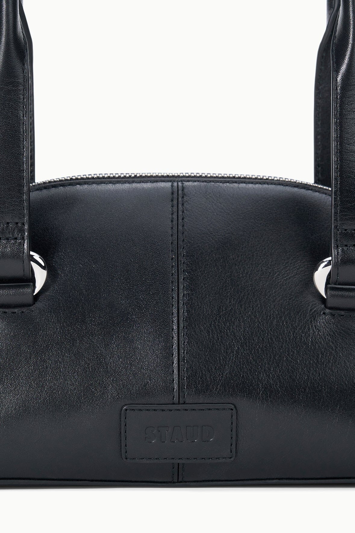 Mini shoulder bag close-up with stitched front and embossed logo patch