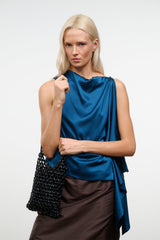 Black beaded mini tote bag held at shoulder, featuring knotted short handles