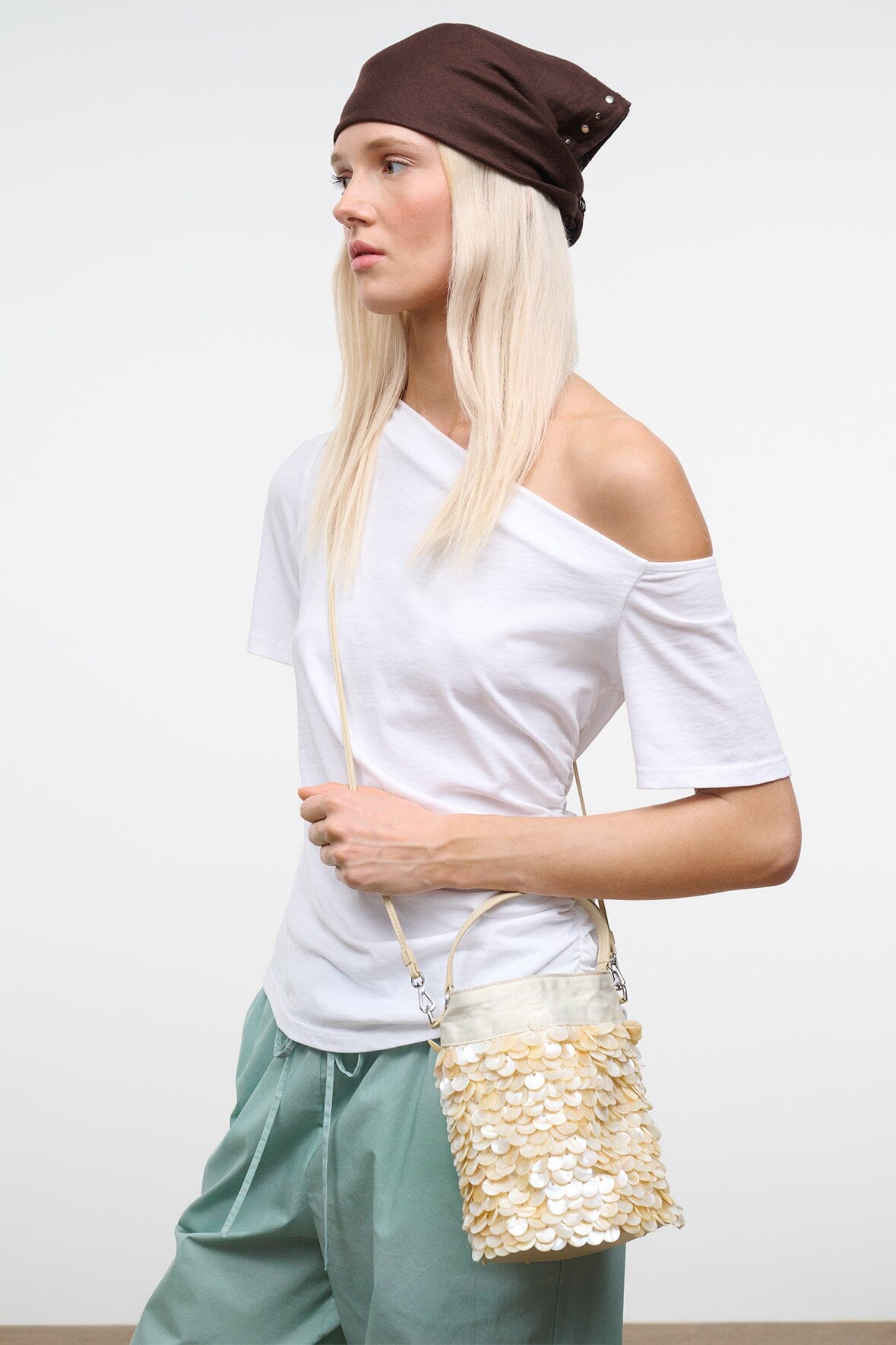 Cream sequin LILA mini bag with chain shoulder strap and flap closure, worn view