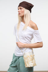 Cream sequin LILA mini bag with chain shoulder strap and flap closure, worn view