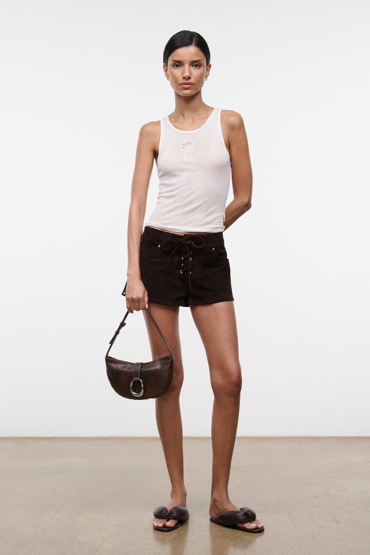 Espresso-brown crescent shoulder bag worn at side, silver O-ring clasp
