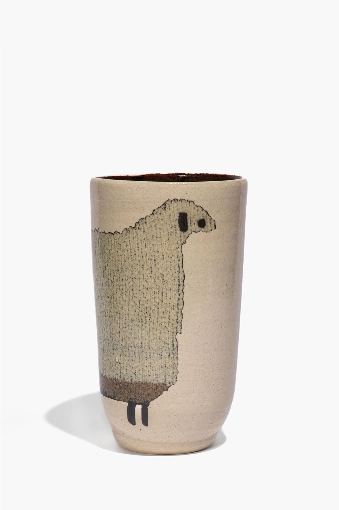 Tall ceramic sheep vase with dark sheep silhouette, small legs on beige