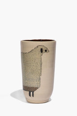Tall ceramic sheep vase with dark sheep silhouette, small legs on beige