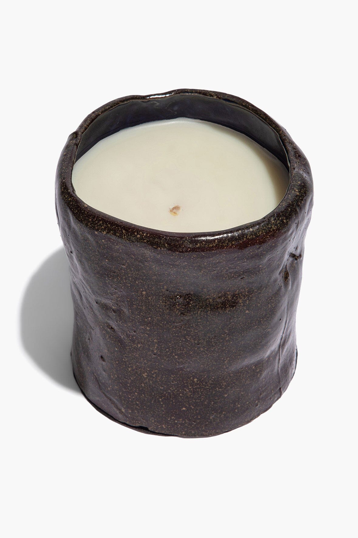 Dark speckled ceramic candle with open top and white wax insert
