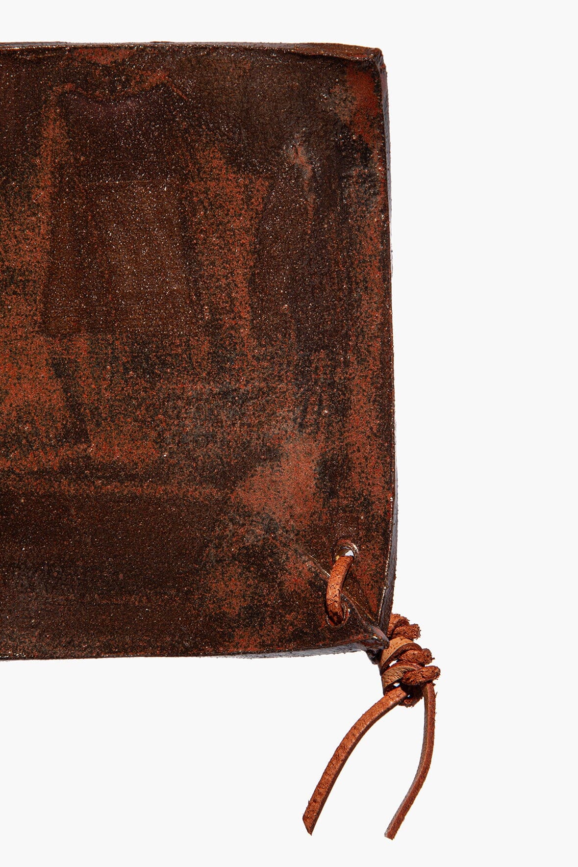 Square ceramic coaster corner with dark burnt sienna speckled glaze and braided cord tie