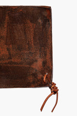 Square ceramic coaster corner with dark burnt sienna speckled glaze and braided cord tie