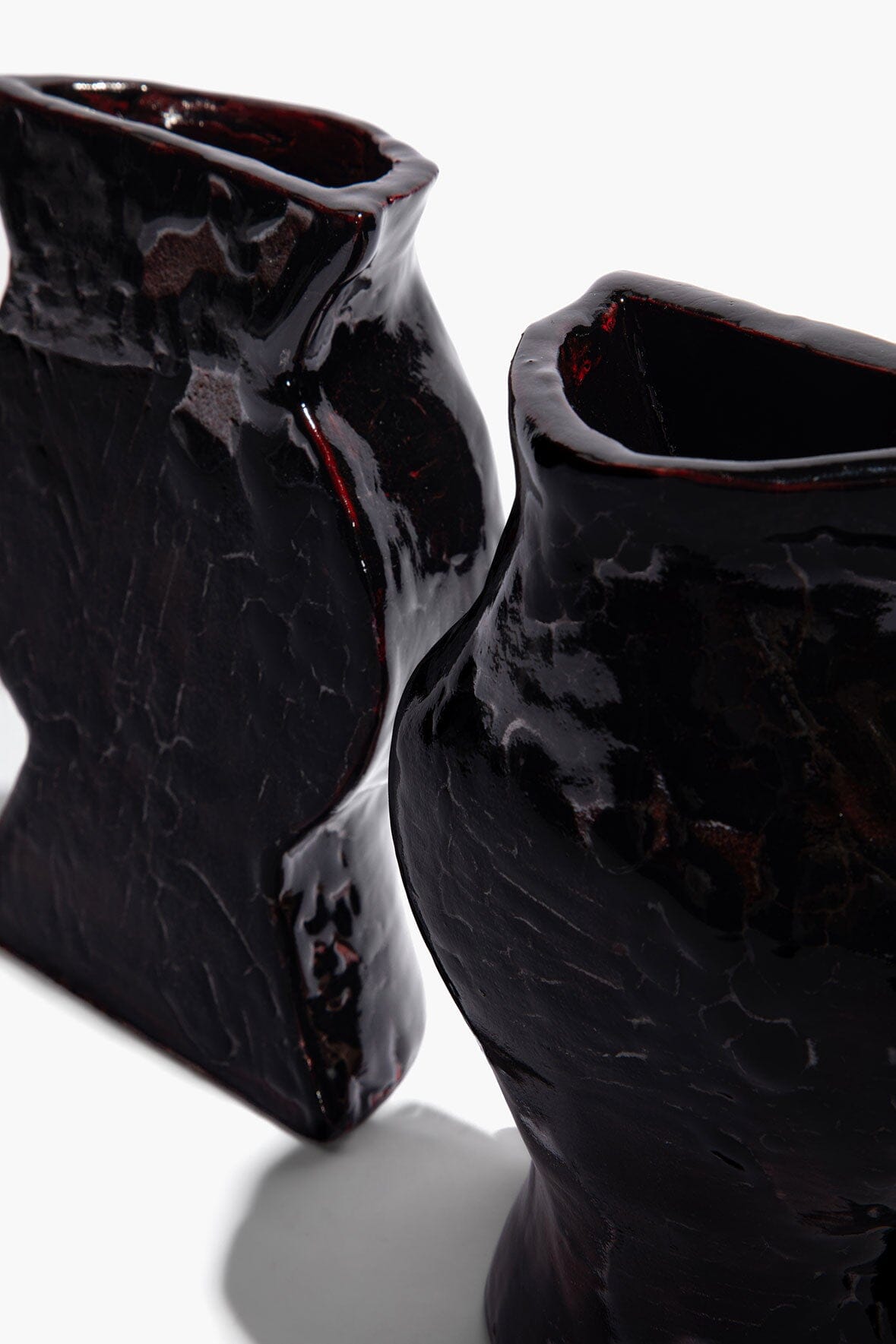 Black glossy ceramic vase bookends, close-up of curved side openings