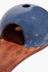 Close-up blue incense holder dome with circular vent and burnt orange interior