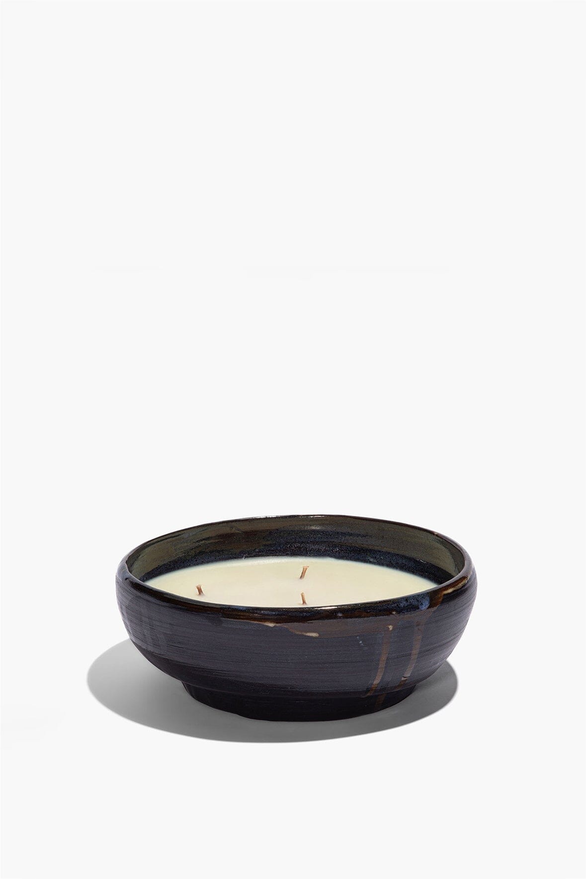 Large ceramic candle bowl with off-white wax top and dark glazed rim