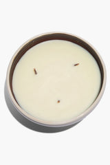 Large ceramic candle in white ceramic bowl with cream wax and visible wicks