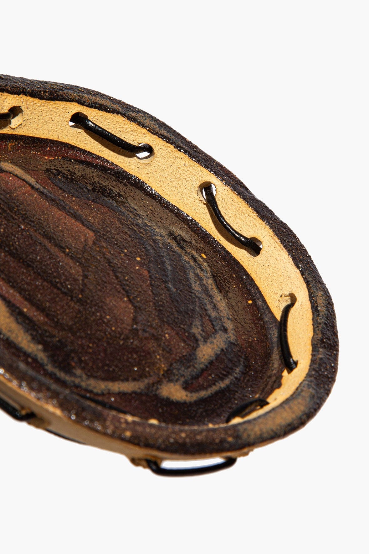 Round ceramic leather-look coaster with studded trim and dark speckled surface