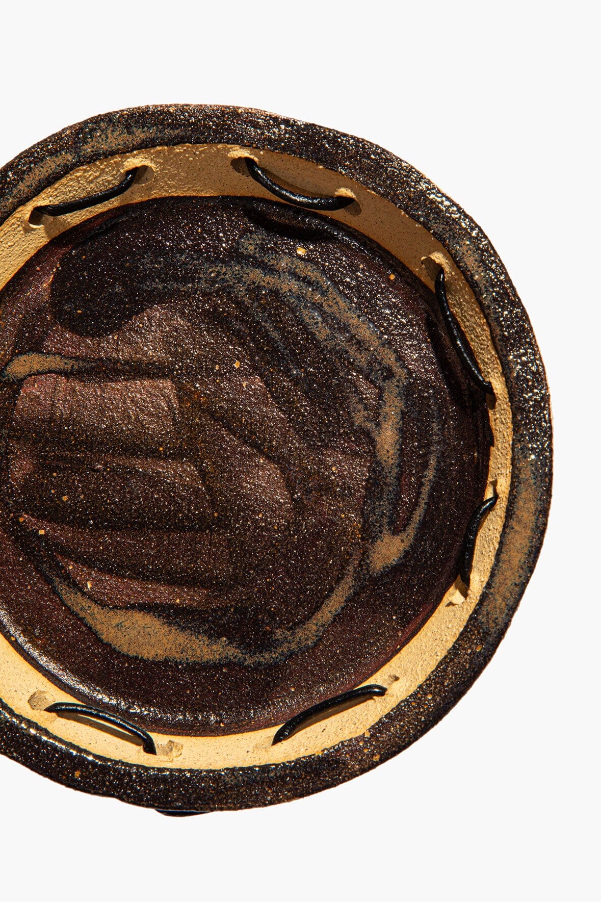 Round ceramic leather-look coaster, top view with curved tan outer ring