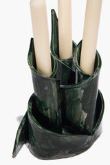 Ceramic triple candlestick holder holding three white candles, forest-green glaze