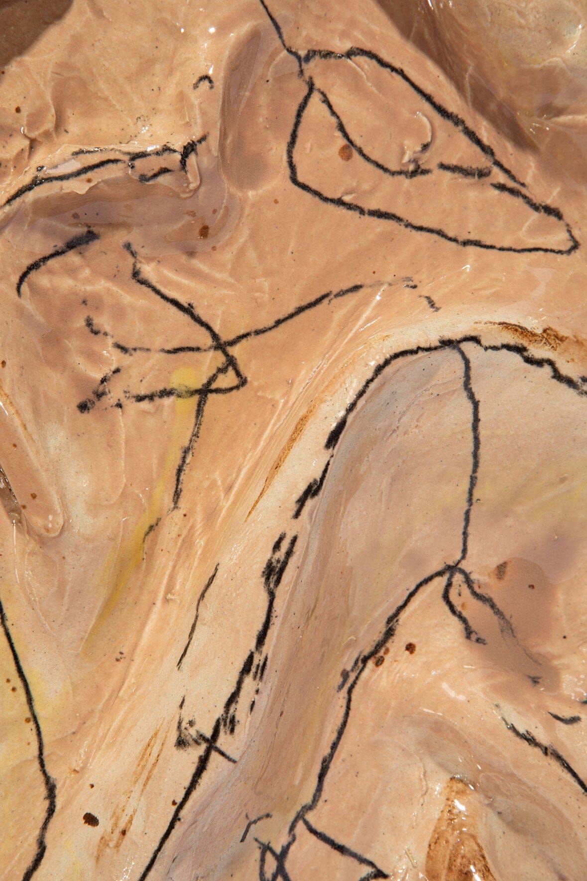 Crinkle glazed ceramic wall art close-up, tan surface with black scribble lines