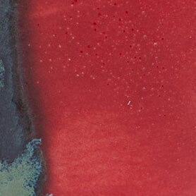 SERRE ceramic candle glaze close-up: red surface with dark teal-blue streaks