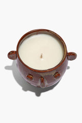 Ceramic candle pot viewed from top, brown rim and side handles; white wax with wick