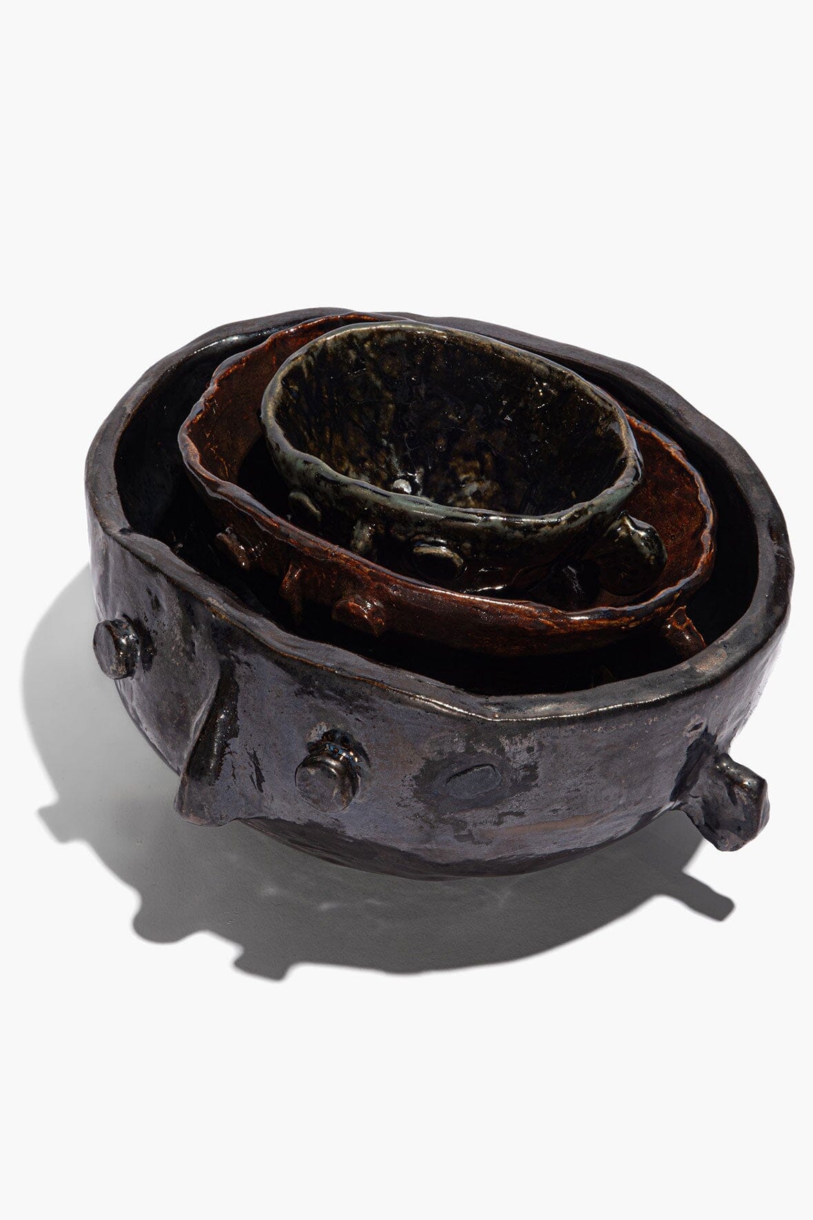 Large Henry bowl side view in dark glaze with sculpted lugs; inner layered glaze shows.