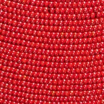 Hand-beaded red surface with dense small beads, tight close-up texture
