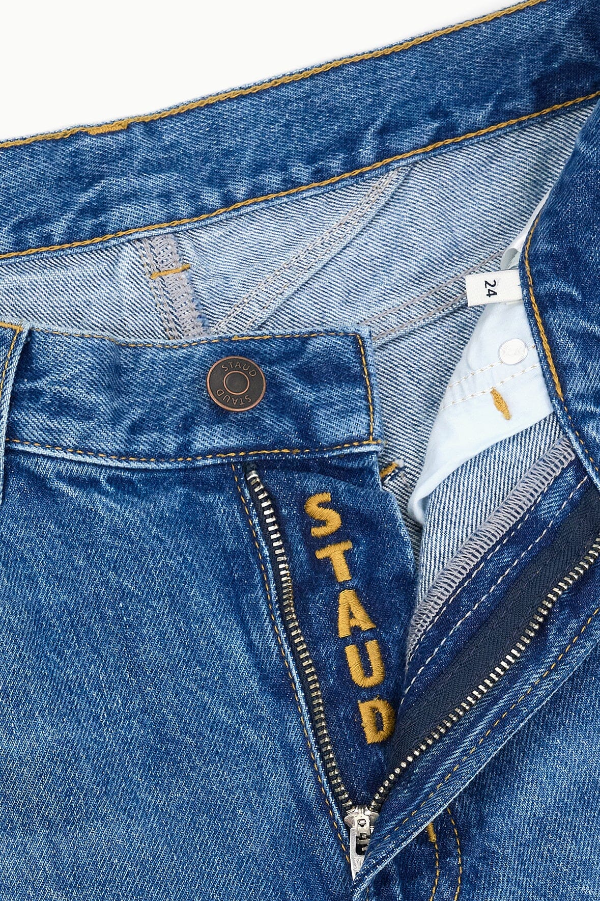 Waistband and zipper detail on vintage wash jeans