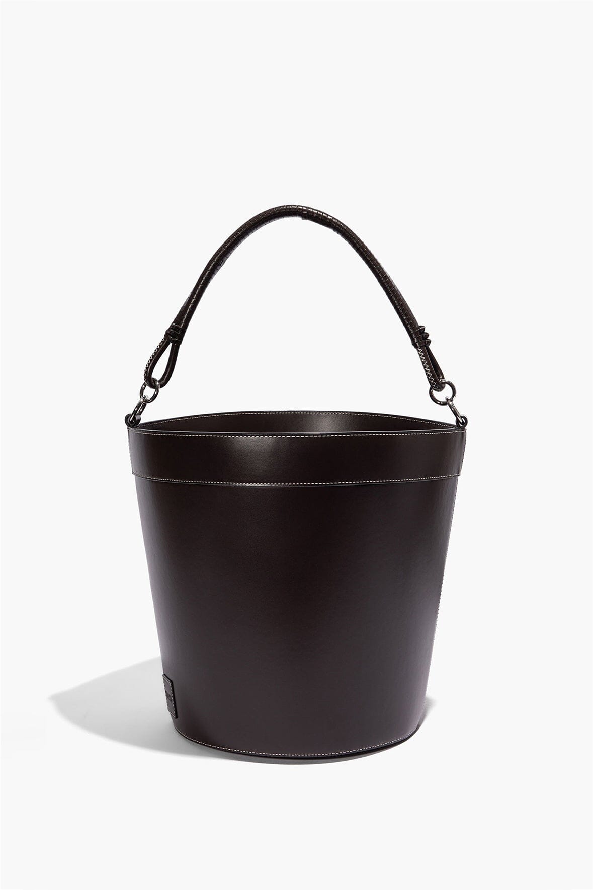 Dark brown leather bin with arched carry handles, stitched rim and smooth bucket silhouette.