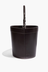 Espresso leather bin with handle, round bucket shape with stitched seams and top strap.