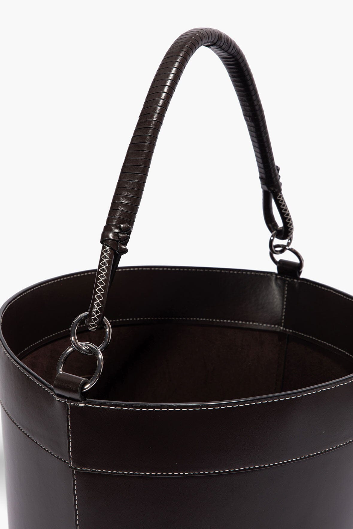 Leather bin with two handle straps and metal rings, open top showing inner lining.