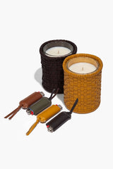 Leather lighter covers with candles in woven holders, dark and amber tones