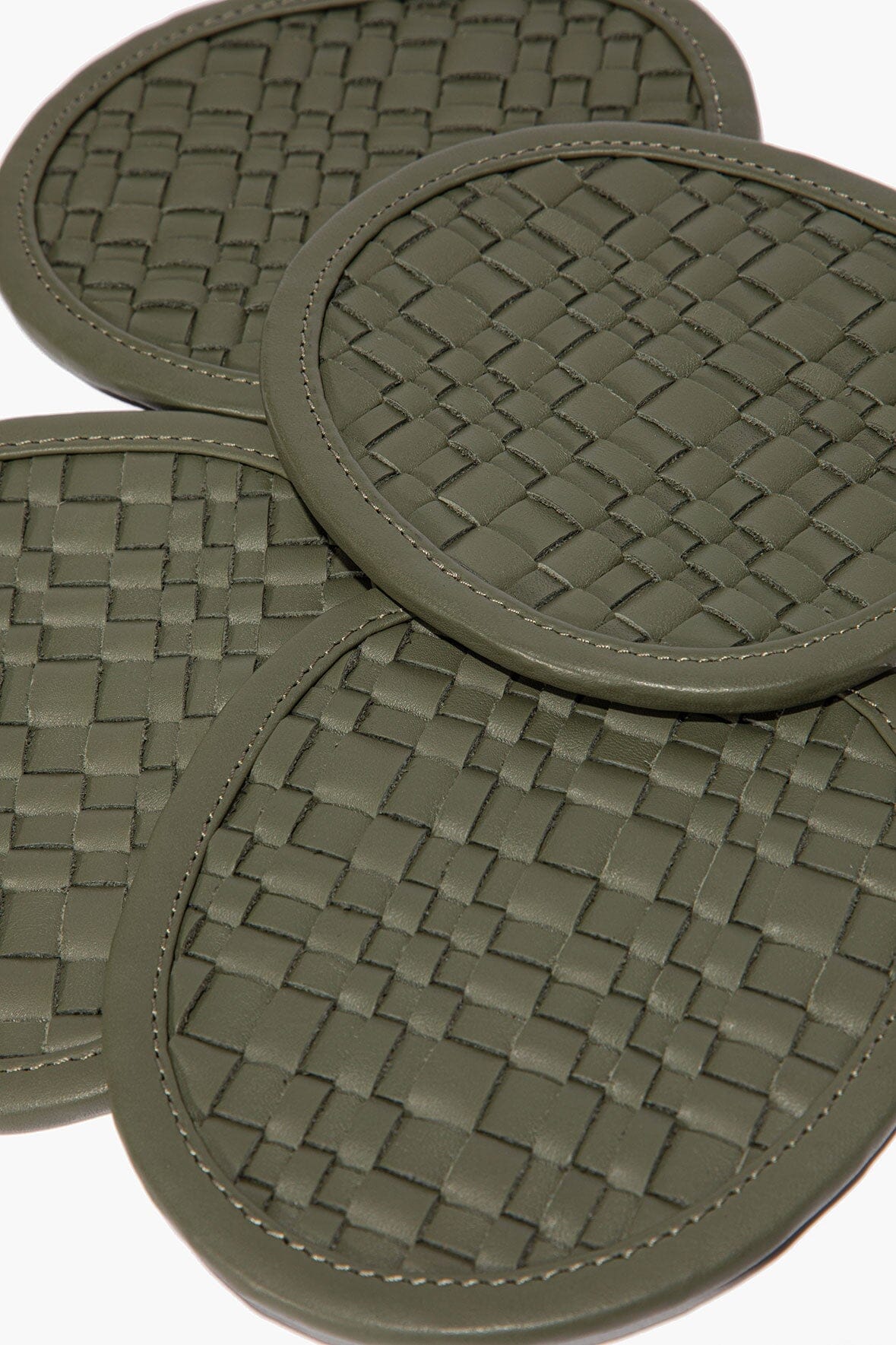 Moss woven leather coaster close-up with round stitched border and checker weave