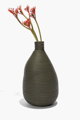 Moss wrapped vase holding a small bundle of red flowers