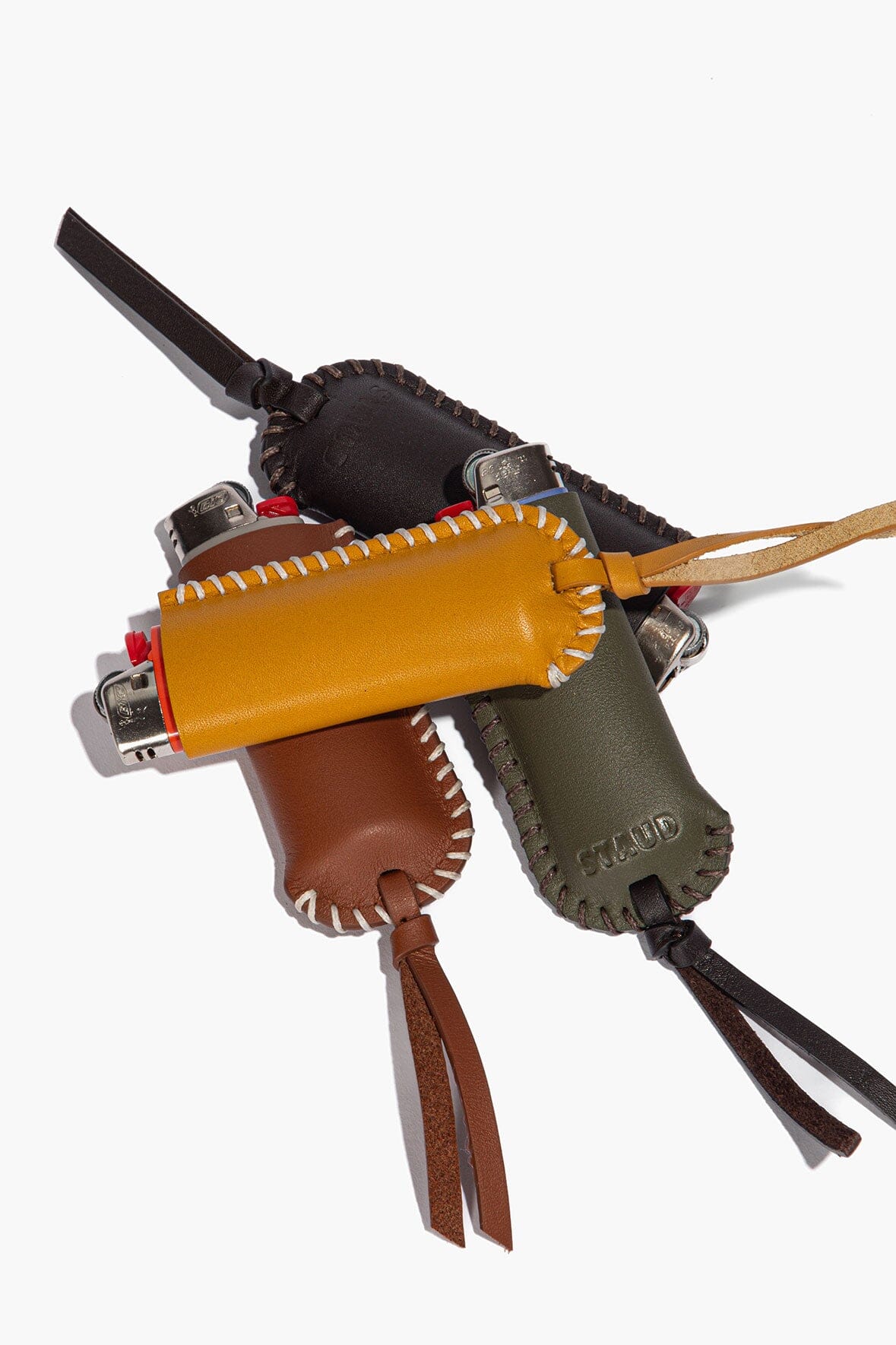 Leather lighter cover with metal clasp, stitched border, and braided tassel ties