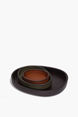 Two nested round leather trays in dark moss tan with contrast-stitched rims