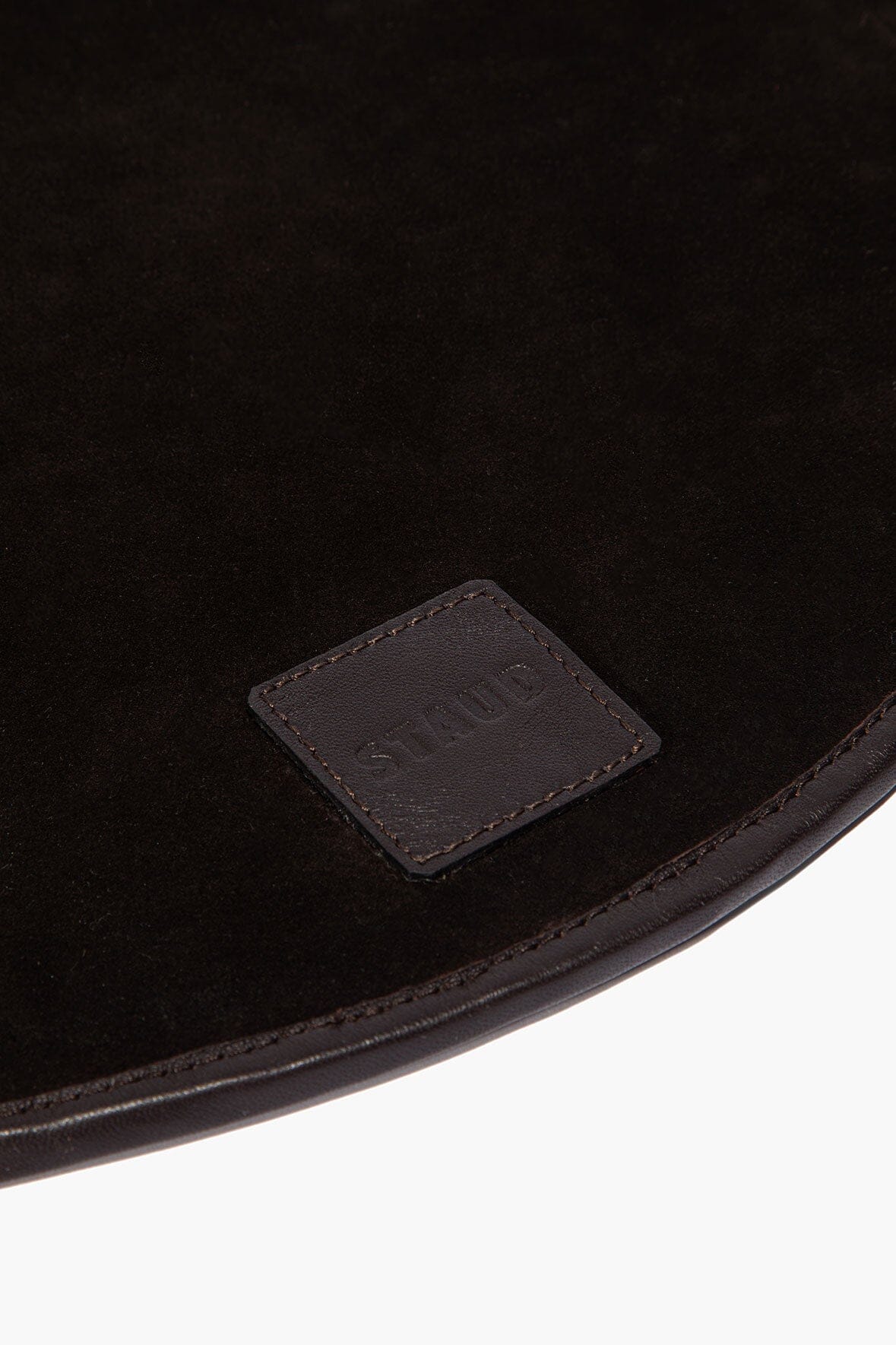 Espresso leather placemat corner with stitched border and embossed logo patch