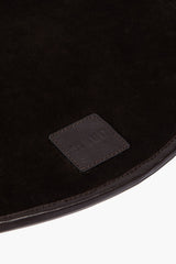 Espresso leather placemat corner with stitched border and embossed logo patch