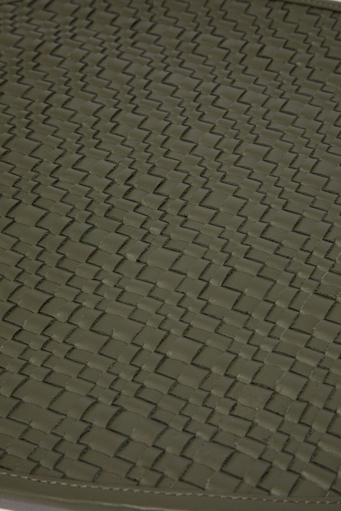 Moss green leather placemat with woven crosshatch texture, close-up